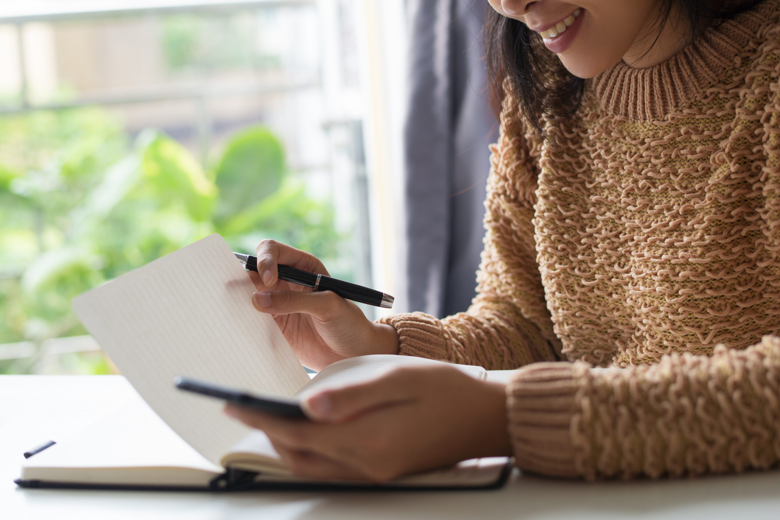 Close-up of smiling lady reading her notes in diary